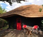 Dutch Barn with Peaceful Undulating Roof Made of Local Reeds