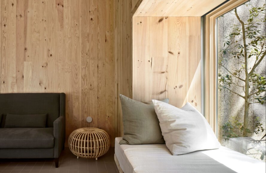 an interior wall with light-hued panels and a seating space