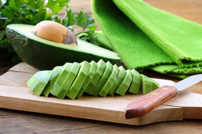 sliced avocado on a wood cutting board