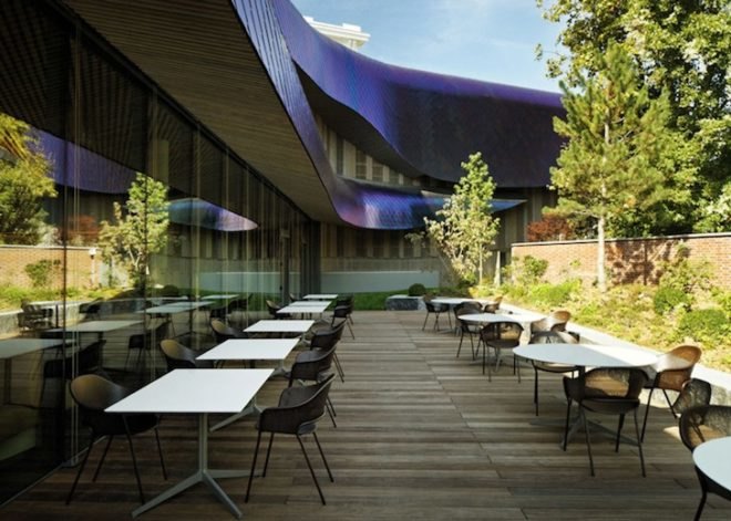 Agence Jouin Manku, office space, amenities wing, Société Foncière Lyonnaise, IN/OUT, iridescent shingles, stainless steel tiles, glass pavilion, bush hammered concrete, contemporary architecture, avant garde architecture