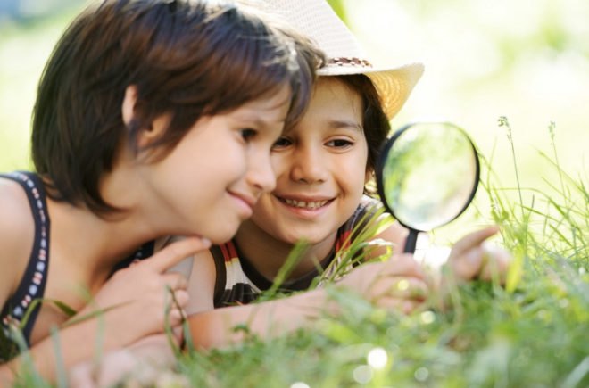 kids outdoors with magnifying glass