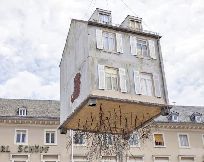 pulled up by the roots, leandro erlich, karlsruhe germany, a city of stars, a city of stars festival, construction art installation, house with roots, house suspended in air, house art exhibit, house art installation