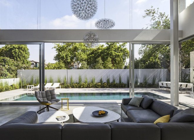 Concrete Cut House, Tel-Aviv, Israel, Pitsou Kedem Architects, concrete, daylit spaces, glass facade, chandelier, swimming pool, family home