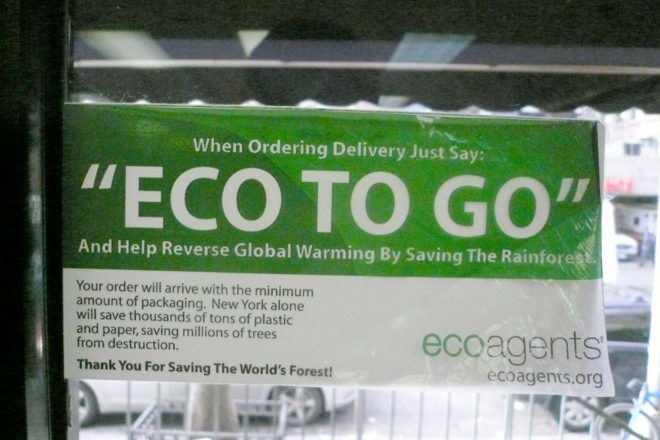 Green and white sign in a window that reads "eco to go"