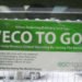 Green and white sign in a window that reads "eco to go"