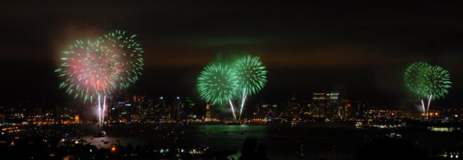 Green fireworks exploding in the sky above a city