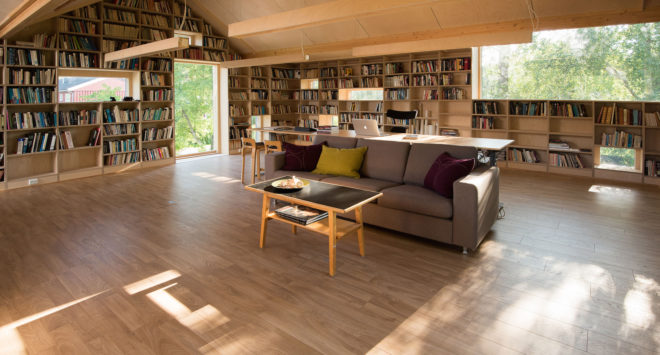 garage converted to library, garage conversions, Tjøme garage library conversion by NOMA Architects, tree-house like library, floor to ceiling bookshelves