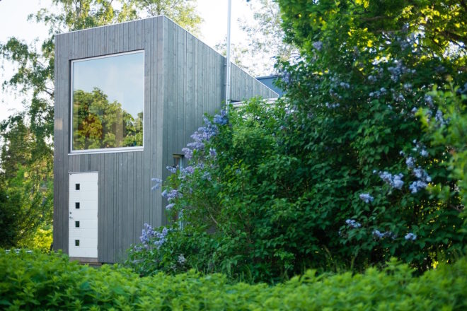 garage converted to library, garage conversions, Tjøme garage library conversion by NOMA Architects, tree-house like library, floor to ceiling bookshelves