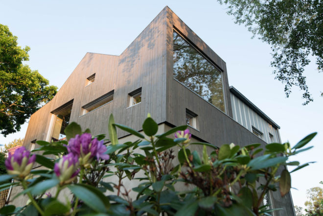 garage converted to library, garage conversions, Tjøme garage library conversion by NOMA Architects, tree-house like library, floor to ceiling bookshelves