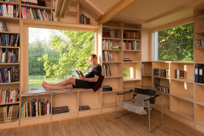 garage converted to library, garage conversions, Tjøme garage library conversion by NOMA Architects, tree-house like library, floor to ceiling bookshelves