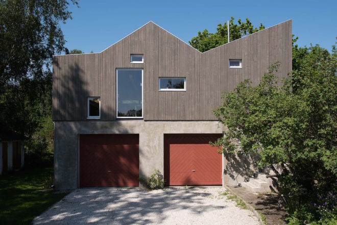 garage converted to library, garage conversions, Tjøme garage library conversion by NOMA Architects, tree-house like library, floor to ceiling bookshelves