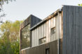 garage converted to library, garage conversions, Tjøme garage library conversion by NOMA Architects, tree-house like library, floor to ceiling bookshelves
