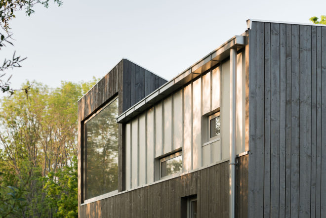 garage converted to library, garage conversions, Tjøme garage library conversion by NOMA Architects, tree-house like library, floor to ceiling bookshelves