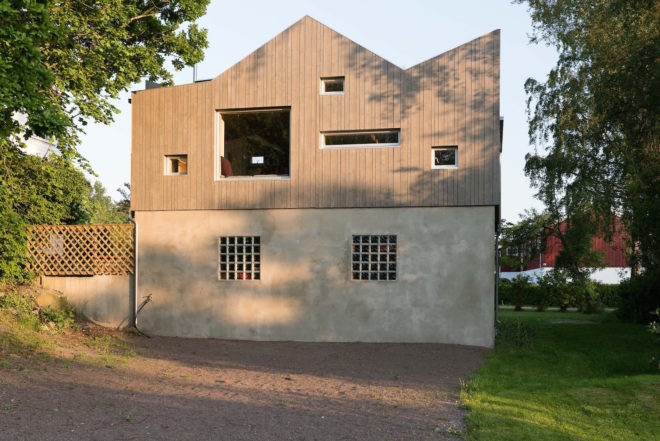 garage converted to library, garage conversions, Tjøme garage library conversion by NOMA Architects, tree-house like library, floor to ceiling bookshelves