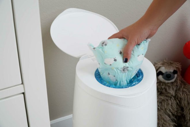 Image of someone throwing away a disposable diaper.