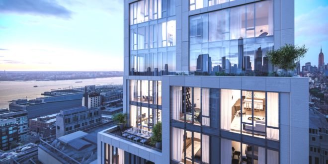 Image shows the exterior of 570 Broome at dusk. The building has tall floor-to-ceiling windows. and is surrounded by impressive views of New York City's buildings.