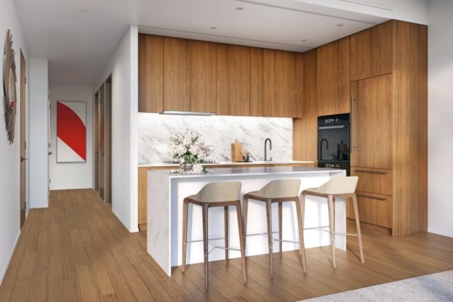 The kitchen area has an island with bar stools and modern wood cabinets.