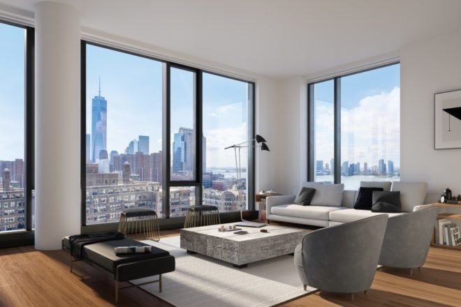 A condo has modern black and white furniture, wood floors, and several tall windows with views of the city.