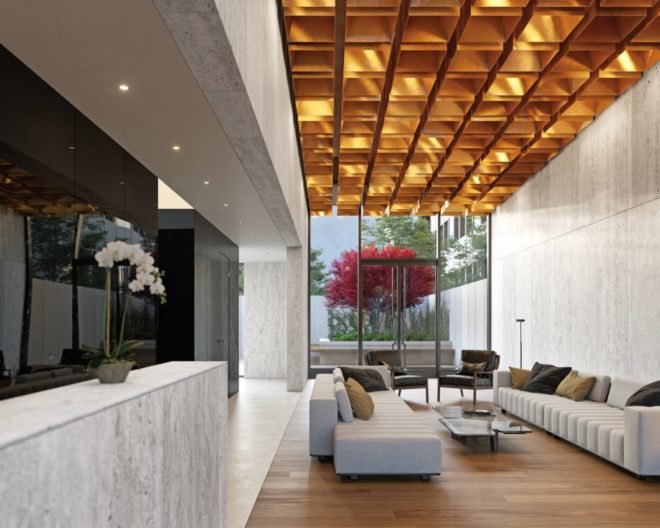 The lobby has long white couches with several neutral brown pillows. The lobby has floor-to-ceiling windows that look out onto the entry garden and the Japanese maple tree.