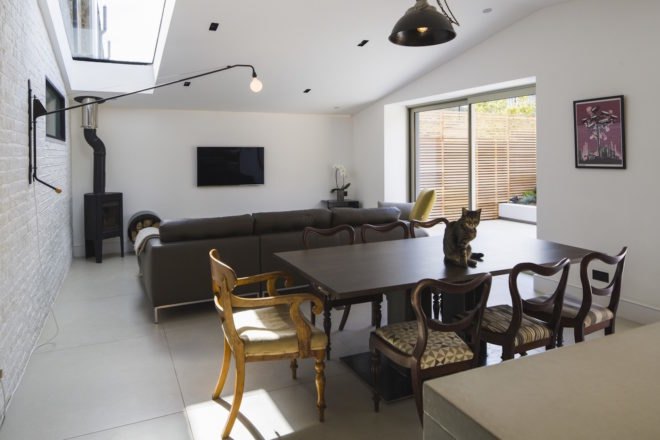 In front of the dining table is a couch and wall-mounted TV