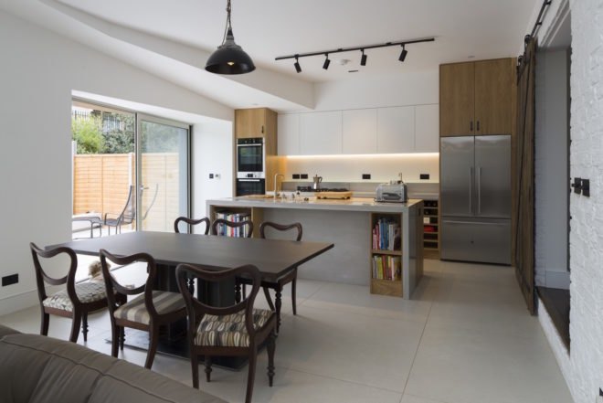 Just behind the dark wooden dining table is the kitchen