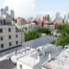 Solar panels are raised above a NYC rooftop.
