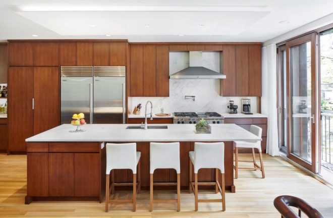 Modern kitchen, featuring wood cabinetry and a large island, in historic renovation Brooklyn passive plus house by Baxt Ingui Architects