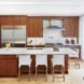 Modern kitchen, featuring wood cabinetry and a large island, in historic renovation Brooklyn passive plus house by Baxt Ingui Architects