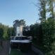 The home is built into a grassy slope and surrounded by trees.