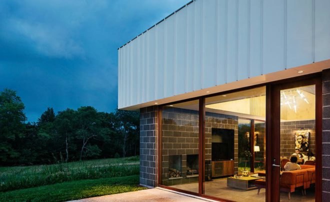 The cabin is surrounded by fields and trees.
