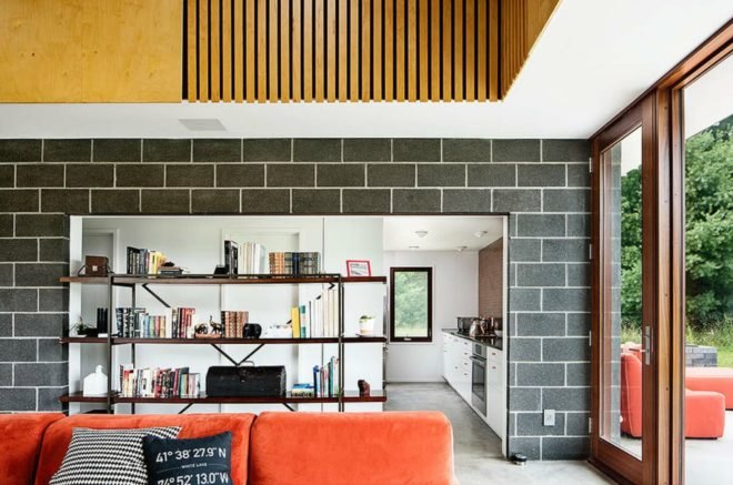 Inside the home, open book shelves separate the main living space from the kitchen.