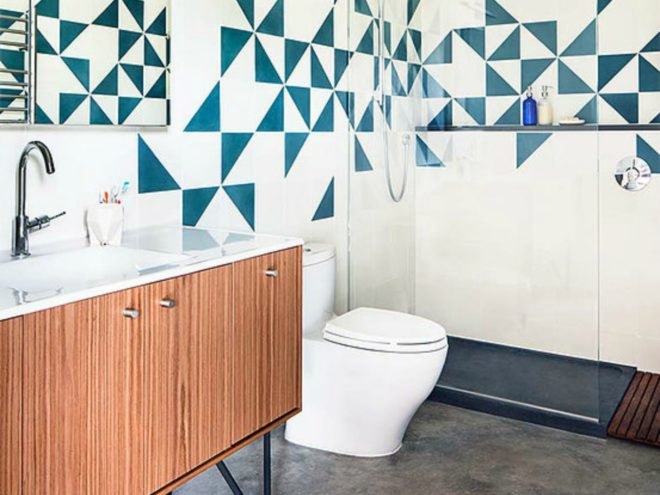 The bathroom features unique blue and white tiled walls and a shower with a glass door.