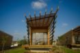 The front of the bungalow features large sliding glass doors, a deck, and an expanded pergola.