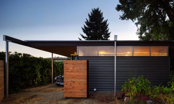 Image of the black metal and wood studio and the car port.