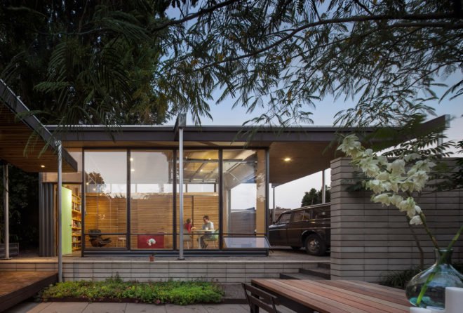 The studio's glass walls reveal two people sitting inside at the white table and chairs.