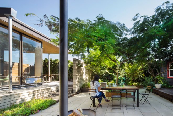 A woman uses her laptop while sitting outside in the courtyard.