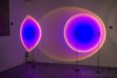 Halo Light by Mandalaki projects bold hues of blue and purple on a nearby wall.