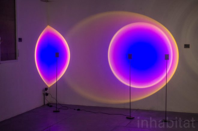 Halo Light by Mandalaki projects bold hues of blue and purple on a nearby wall.