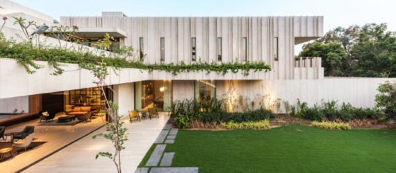 Exterior image of the stone home which is filled with green plants.