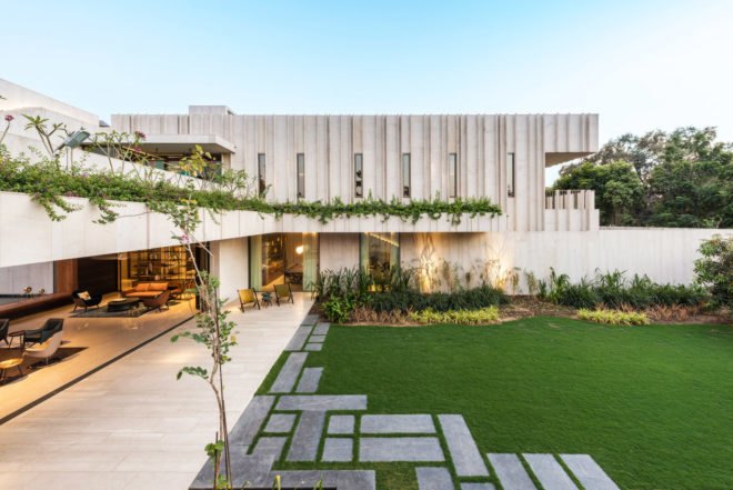 Exterior image of the stone home which is filled with green plants.