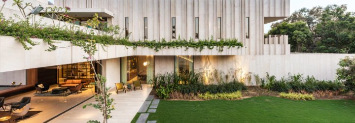 Exterior image of the stone home which is filled with green plants.