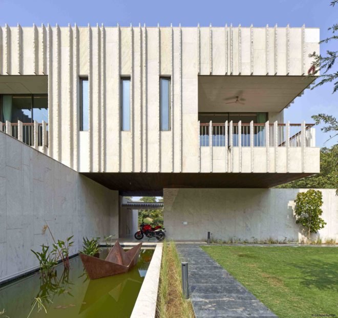 Along one exterior wall of the home is a reflective pond.