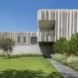 The monolithic stone home contrasts with the luscious green gardens.
