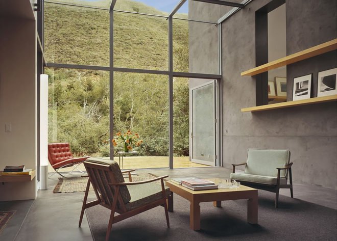 Inside, large glass windows cover one wall, other walls are concrete