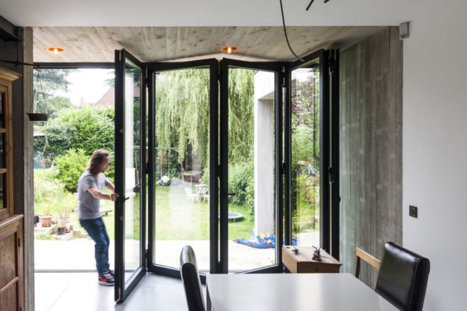 MILU by Qatarchitecten, green roof concrete extension, MILU house in Ghent, Ghent renovation and extension, board formed concrete extension, board formed concrete structural walls, operable glass garden backyard doors,