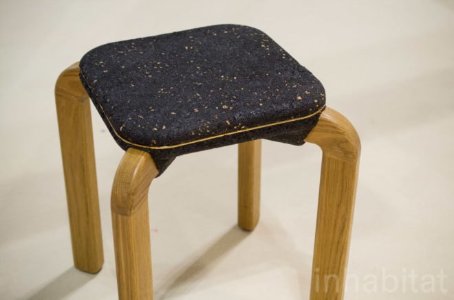 Macaron seat by Kalo features sturdy wooden legs and a dark rubber seat.