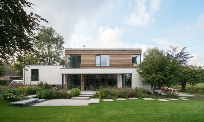Image of the exterior of the home shows its large windows, designed to let in plenty of natural light.
