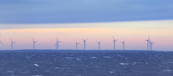Offshore wind turbines in the sea at sunset