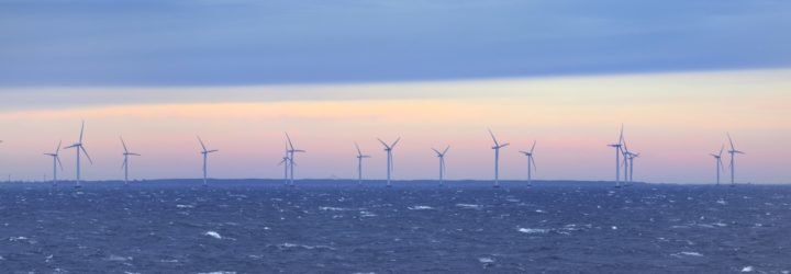 Offshore wind turbines in the sea at sunset