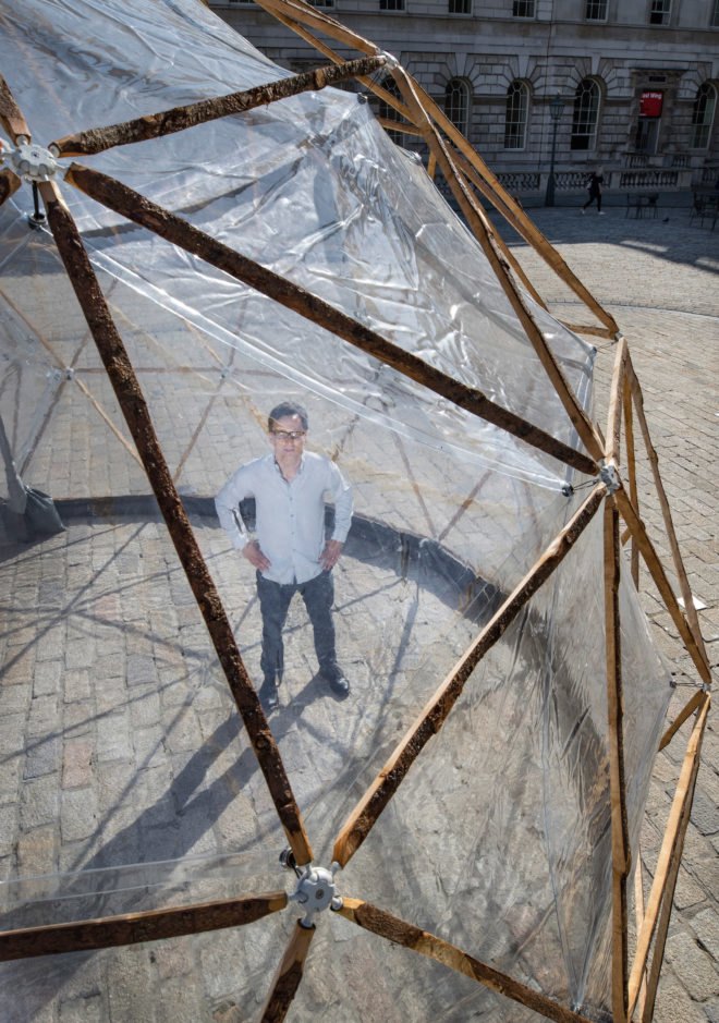 Michael PInsky posing inside Pollution Pods by Michael Pinsky